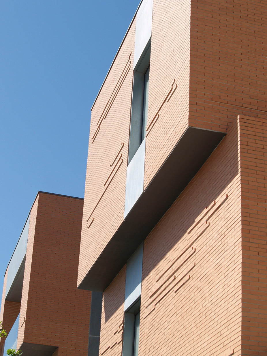 Fachada con ladrillo cerámico salmón en aparejo rústico